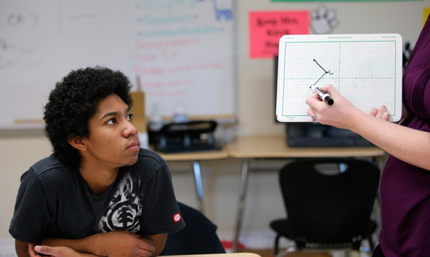 Noah Reyes, 11th grader, watches as teacher Crystal Kirch solves a problem in a pre-calculus class at Segerstrom High School in Santa Ana, California, Wednesday, January 16, 2013. (AP/Jae C. Hong)