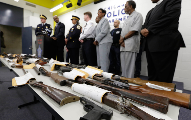 Chicago Police First Deputy Superintendent Alfonsa Wysinger, second from left, accompanied by Deputy Chief Wayne Gulliford, left, speaks at a news conference Monday, January 28, 2013, in Chicago. The pair joined other officers, elected officials, clergy, and community members, with a display of recently recovered firearms from the 574 seized to date beginning January 1, 2013. (AP/M. Spencer Green)