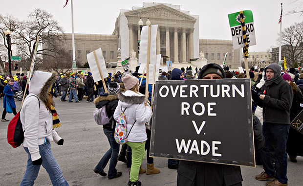Antiabortion activists march past the U.S. Supreme Court in Washington, Friday, January 25, 2013, as they observe the 40th anniversary of the <em>Roe v. Wade</em> decision. (AP/J. Scott Applewhite)