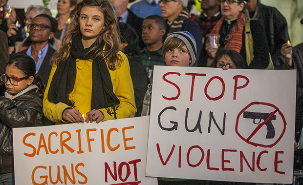 Students Zoe Bell, 12, left, and her sister, Sophie, 9, join Los Angeles-area clergy, religious leaders, and citizens in an interfaith candlelight prayer vigil to end to gun violence outside Los Angeles City Hall, Wednesday, December 19, 2012. (AP/Damian Dovarganes)