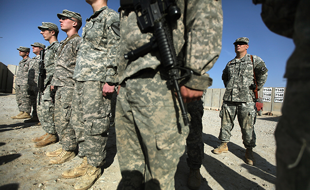 In this December 17, 2011, photo, soldiers from the 3rd Brigade, 1st Cavalry Division, attend a casing of the colors ceremony by handwritten names of soldiers at Camp Adder, now known as Imam Ali Base, near Nasiriyah, Iraq. (AP/Mario Tama)