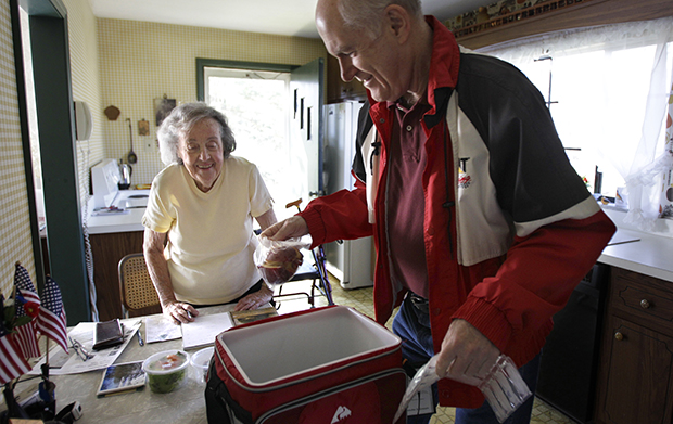 Marty Robertson unpacks food from the Chagrin Falls Meals on Wheels program for recipient Bernadette Winko, 90, in her Bentleyville, Ohio, home, Wednesday, March 14, 2012. The Ryan budget’s additional $900 billion in nondefense discretionary spending cuts would further impede the ability of Meals on Wheels to combat senior hunger. (AP/Amy Sancetta)