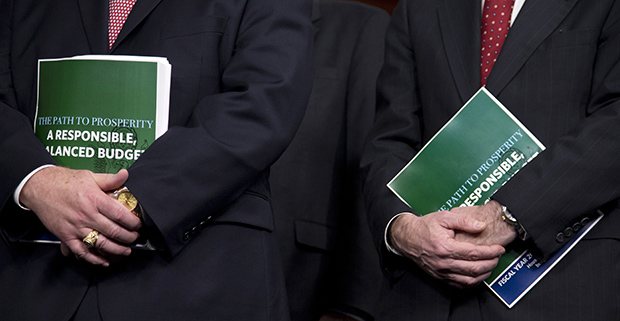 Rep. Bill Flores (R-TX), left, and Rep. Scott Garrett (R-NJ) hold copies of the FY 2014 budget resolution during a news conference with House Budget Committee Chairman Paul Ryan (R-WI), Tuesday, March 12, 2013, on Capitol Hill in Washington. (AP/Carolyn Kaster)