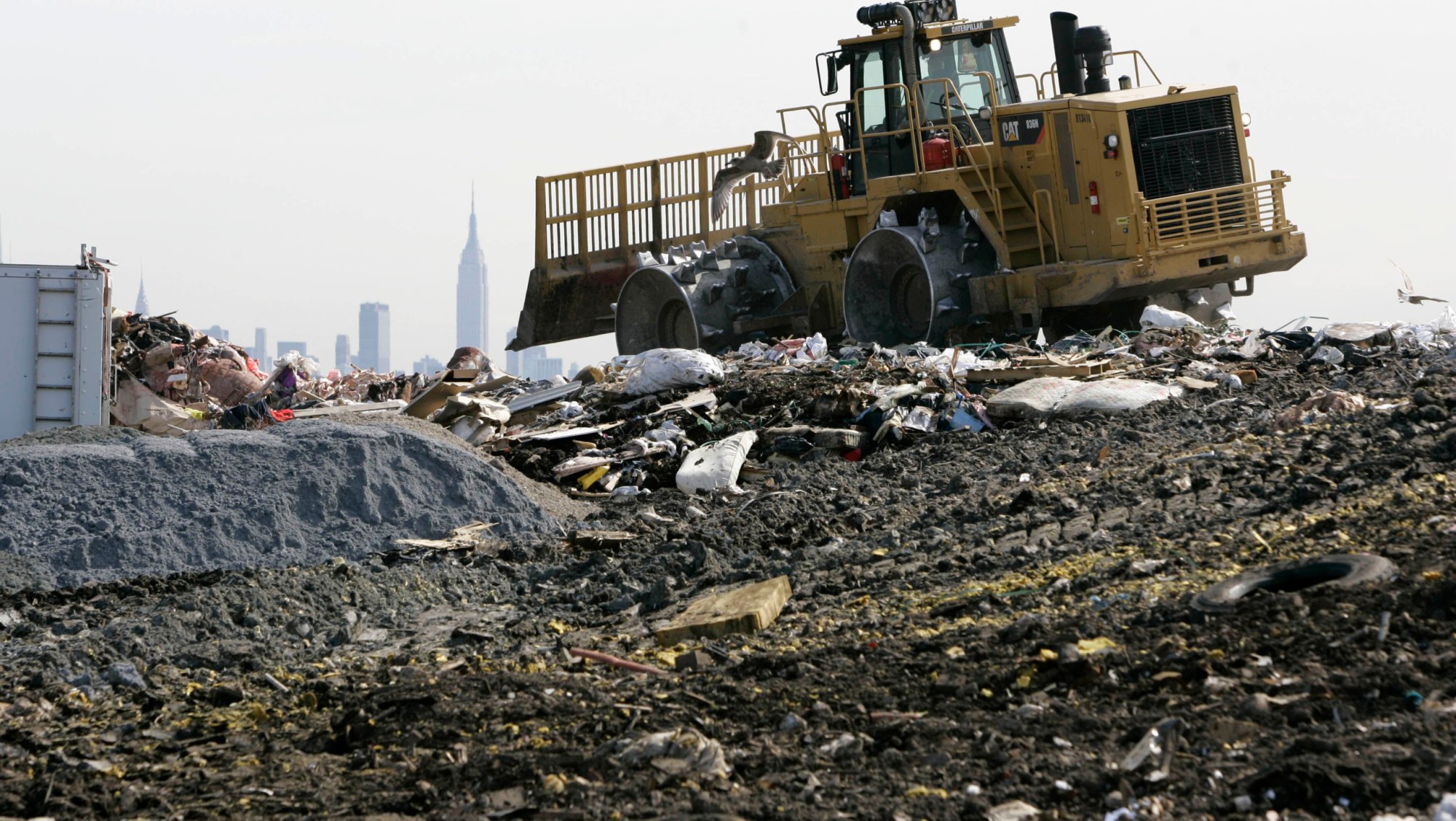 A large tractor moves trash and garbage around on top of 1-E landfill in Kearny, New Jersey. The Kearny site is among 21 landfills in New Jersey that convert methane gas produced by decomposing trash into electricity. (AP/Mike Derer)