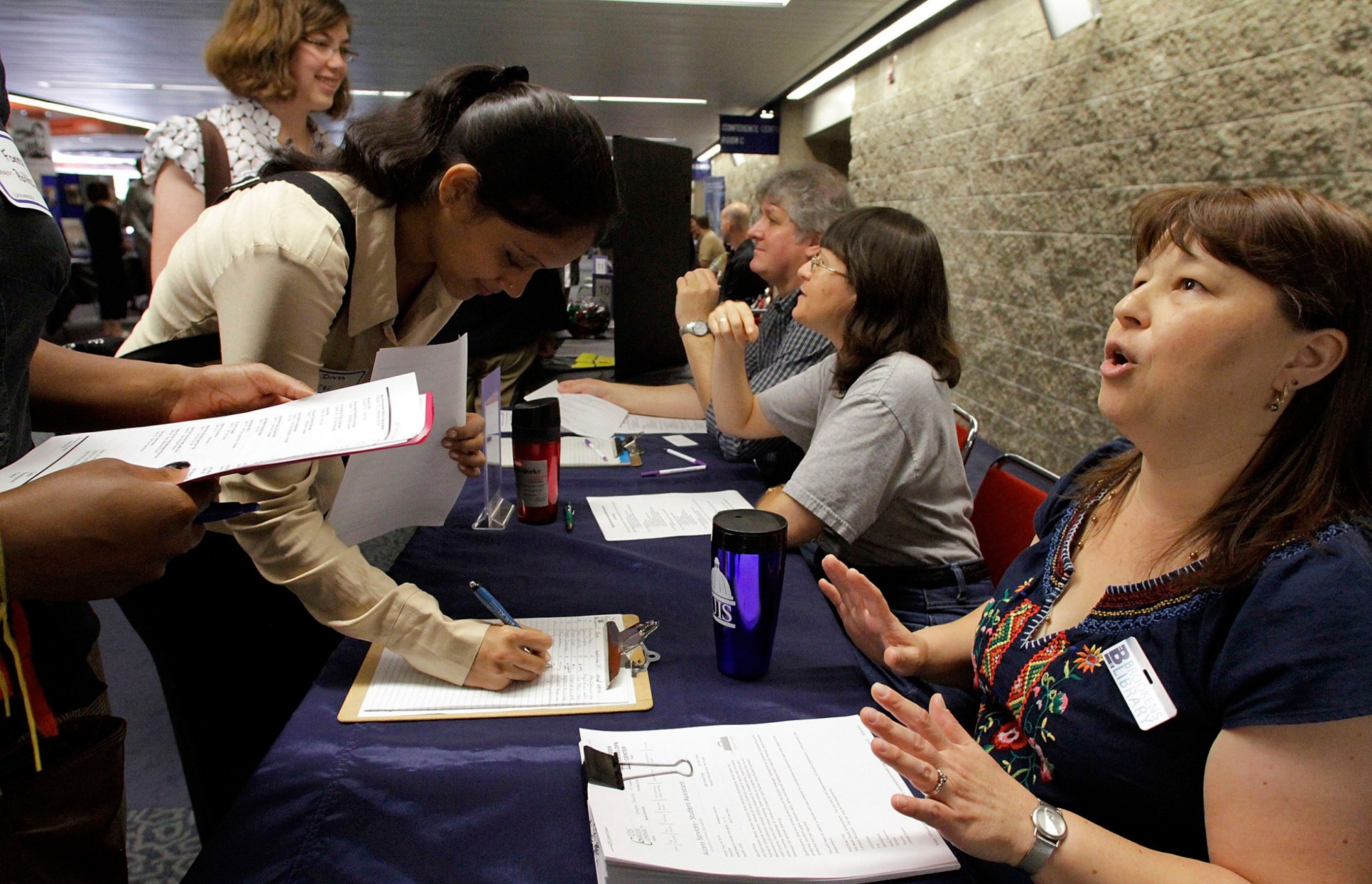 Gloria Newton Davlantis speaks with students seeking employment during a University of Illinois Job Fair in Springfield, Illinois. Higher Education based on credit hours in the United States often leave graduate unprepared for jobs. (AP/Seth Perlman)