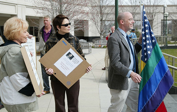 Joanne Polisano, left, Mary Czartoryski, center, and Stephen Eddins join others in a rally outside the Michigan Hall of Justice in Lansing, Michigan, on April 11, 2006, following a state court of appeals hearing on whether governments and public universities can provide health insurance and other benefits to the partners of gay employees without violating the state constitution. (AP/Al Goldis)