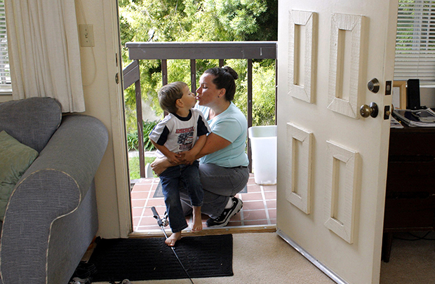 Child care aid recipient Sarah Comito kisses her son Matthew at their home in Oxnard, California. (AP/Damian Dovarganes)