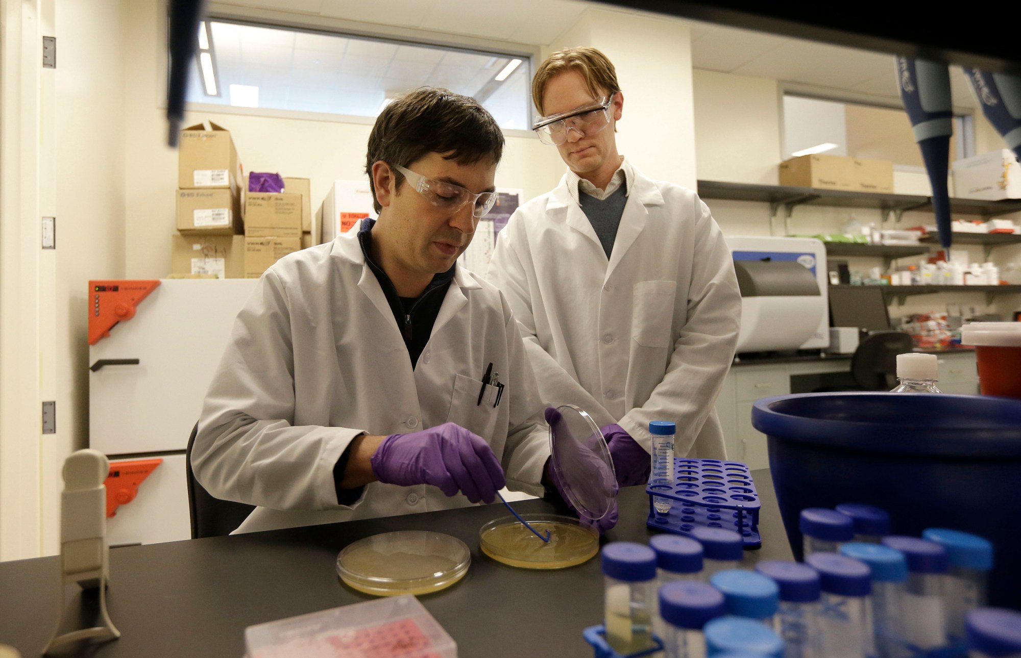 Scientists Matt Drever and Charlie Holst conduct an experiment at the Pfizer laboratory at the University of California at San Francisco. Sequestration will result in substantial cuts to federal funding for research and development. (AP/ Jeff Chiu)