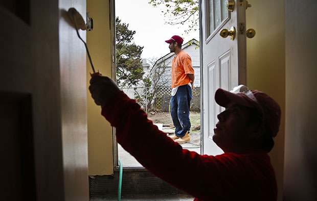 Victoriano Del La Cruz, 36, a carpenter from Mexico, stands just outside a basement entrance as Sergio Ajche, 29, from Guatemala, finishes a painting job in New York, May 7, 2013. Providing undocumented immigrants with a pathway to legalization and citizenship would have many benefits for the U.S. economy, (AP/Bebeto Matthews)