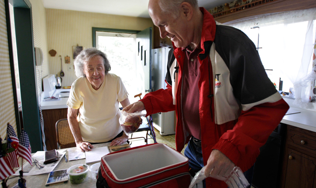 Marty Robertson unpacks food from the Chagrin Falls Meals on Wheels program for recipient Bernadette Winko, 90, in her Bentleyville, Ohio, home on Wednesday, March 14, 2012. If CDBG funding is slashed, seniors will have to adjust to 4 million fewer meals delivered by Meals on Wheels. (AP/Amy Sancetta)