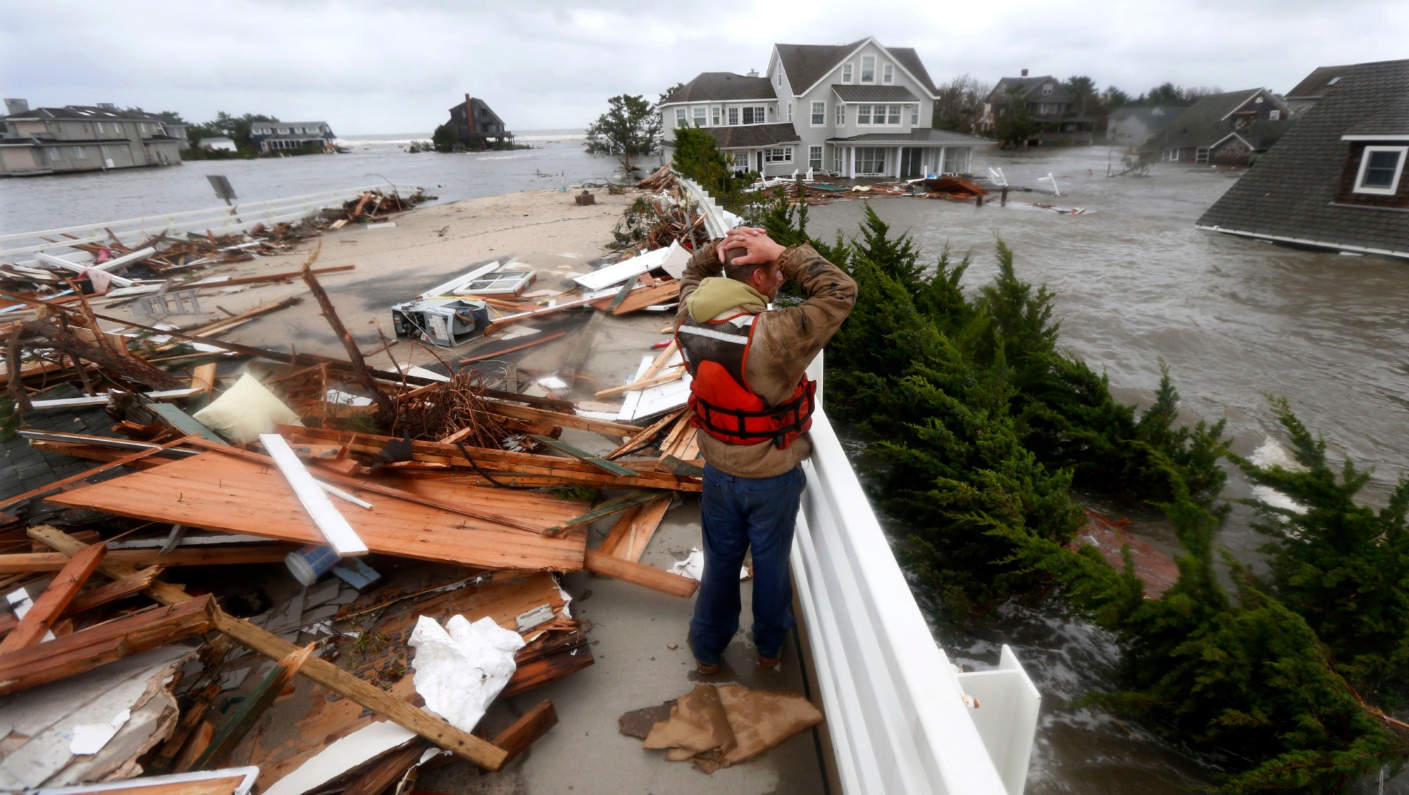 Brian Hajeski of Brick, New Jersey, reacts as he looks at debris of a home that washed up onto the Mantoloking Bridge the morning after Superstorm Sandy made landfall in October 2012. (AP/Julio Cortez)