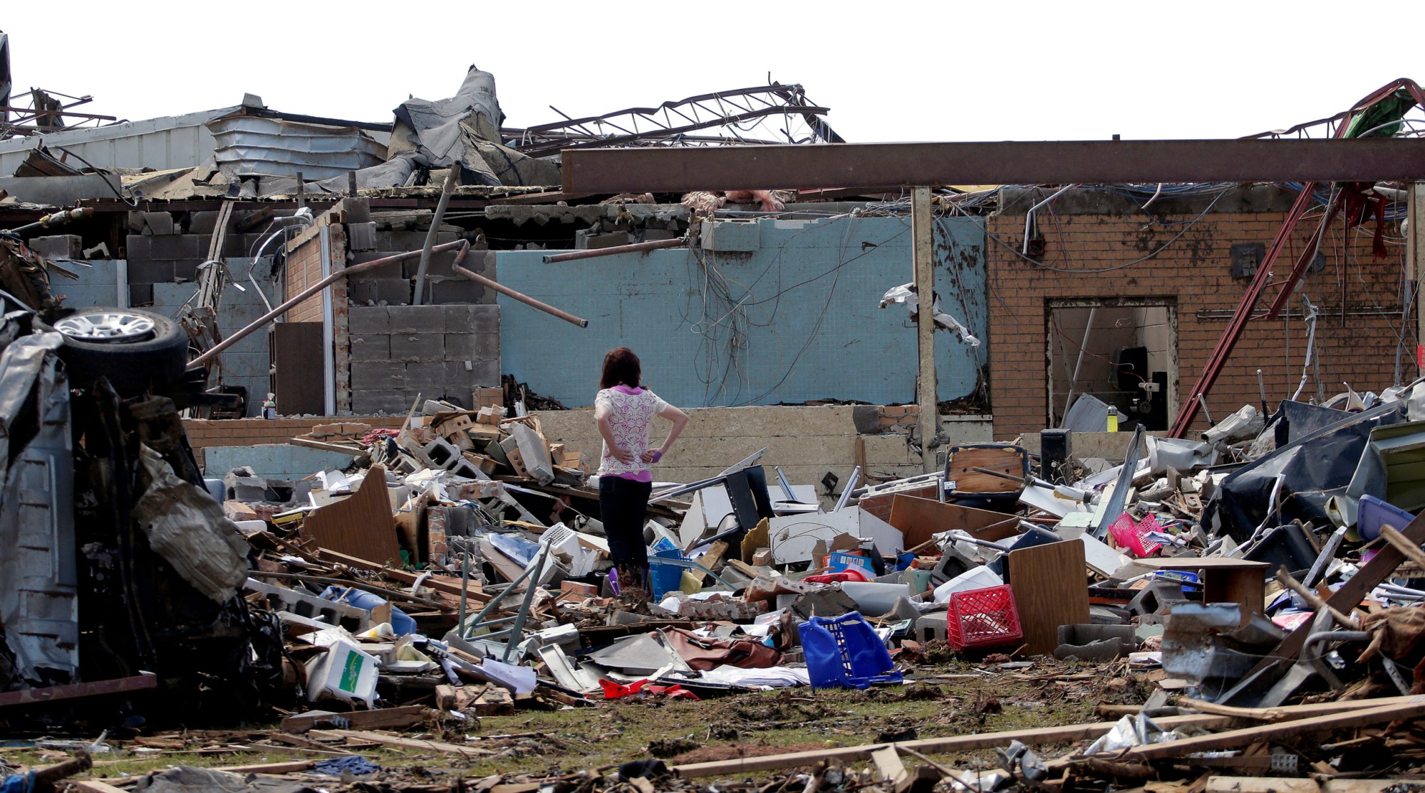 An unidentified woman surveys the scene at the tornado-ravaged Plaza Towers Elementary school on May 23, 2013, in Moore, Oklahoma. (AP/Charlie Riedel)