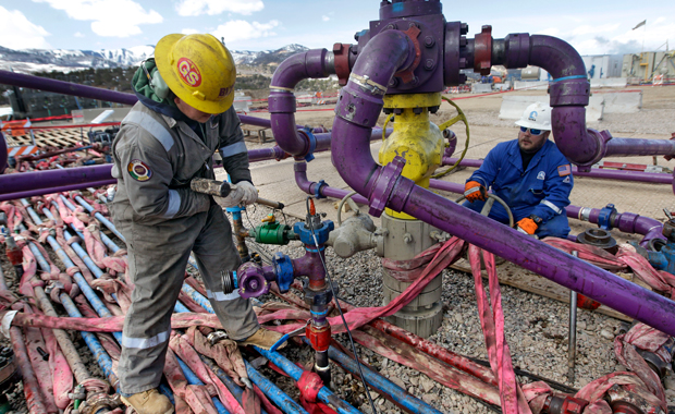 In this March 29, 2013 photo, workers tend to a well head during a hydraulic-fracturing operation at an Encana Oil & Gas (USA) Inc. gas well outside Rifle, Colorado. (AP/Brennan Linsley)