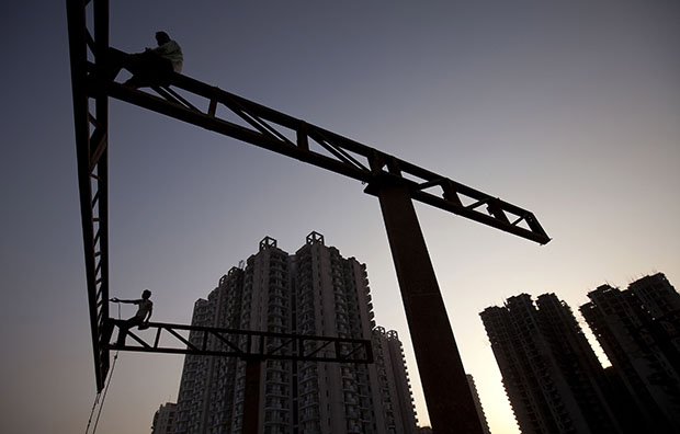 Indian laborers work at a construction site near the Noida Extension on the outskirts of New Delhi, India, September 26, 2011. (AP/Kevin Frayer)