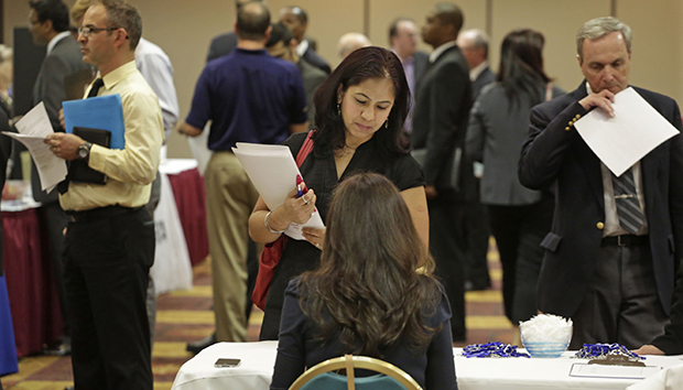 In this May 29, 2013, photo, job seeker Anu Vatal of Chicago speaks with Patrice Tosi of BluePay, seated, during a career fair in Rolling Meadows, Illinois. (AP/M. Spencer Green)