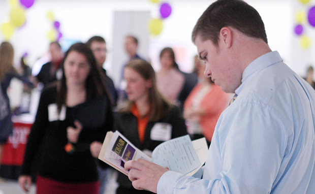 In this April 4, 2012, file photo, Scott Richards of Saint Anselm College looks over possible jobs during a career fair for college students in Manchester, New Hampshire. (AP/Jim Cole)