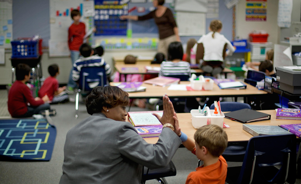 Gloria Thomas, left, an aspiring principal in residency, gives a high-five to fourth grader Christopher Rainey during a class visit at Rock Springs Elementary School, in Lawrenceville, Georgia, Wednesday, October 12, 2011. (AP/David Goldman)