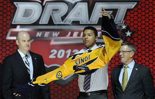 Seth Jones, a defenseman, pulls on a Nashville Predators jersey after being chosen fourth overall in the first round of the NHL hockey draft, Sunday, June 30, 2013, in Newark, New Jersey. (AP/Bill Kostroun)