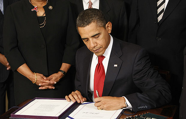 President Barack Obama signs the Ryan White HIV/AIDS Treatment Extension Act of 2009, Friday, October 30, 2009, in the Diplomatic Reception Room of the White House in Washington. (AP/Gerald Herbert)