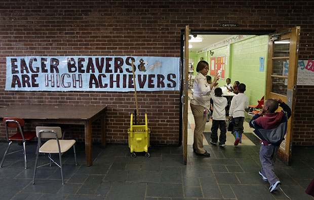 Pre-kindergarten teacher Charisse McNeil leads students into a cafeteria at John Eager Howard Elementary School in Baltimore, Maryland, April 30, 2013. (AP/Patrick Semansky)