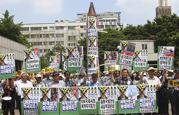 South Korean protesters gather with a mock North Korean rocket, center, and defaced portraits of North Korean leader Kim Jong-un during a rally against North Korea ahead of the 63rd anniversary of the outbreak of the Korean War in Seoul, South Korea, Monday, June 24, 2013. (AP/Ahn Young-joon)