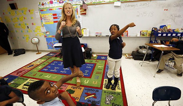In this February 15, 2013, photo, Myrtle Hall IV Elementary School teacher Gabrielle Wooden, left, and Camilyn Anderson, 7, lead their first-grade class in a live-action Spanish class in Clarksdale, Mississippi. (AP/Rogelio V. Solis)