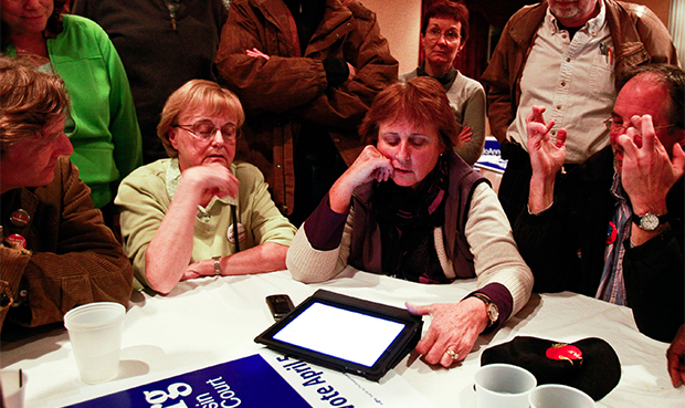 Sue Gatterman, seated second from left, Barbara Schrank, and Fred Schrank, fingers crossed, supporters for Wisconsin Supreme Court candidate JoAnne Kloppenburg, all watch election results in the supreme court race between Kloppenburg and incumbent David Prosser in Madison, Wednesday, April 6, 2011. (AP/Andy Manis)