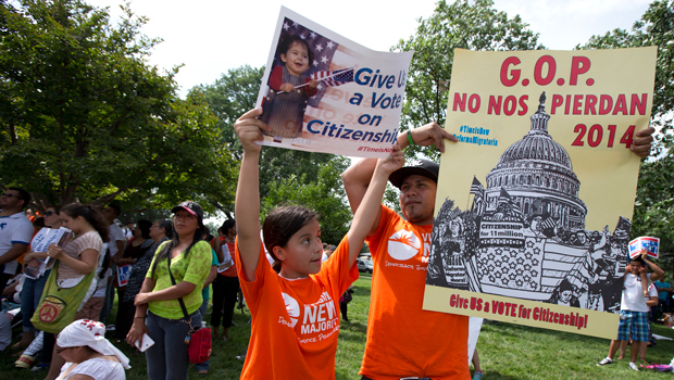 Brian Rossell and his daughter, Kelly Rossell, 11, both from Sonsonate, El Salvador, hold up placards as they join immigration supporters during a rally for citizenship on Capitol Hill in Washington, Wednesday, July 10, 2013. (AP/Manuel Balce Ceneta)