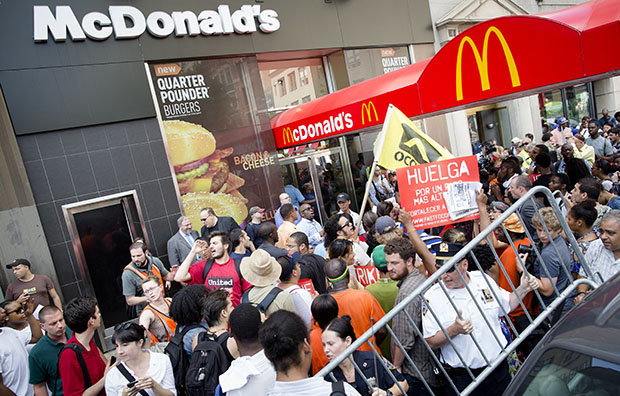 Demonstrators in support of fast-food workers protest outside a McDonald's as they demand higher wages and the right to form a union without retaliation, Monday, July 29, 2013, in New York's Union Square. (AP/John Minchillo)