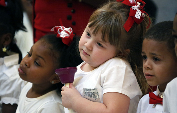 Angel Nevins, center, and her friend and classmate Jade Smith, left, wait for their signal to ring their hand bells as children from the Anderson Grove Head Start program in Caledonia, Mississippi, ring their hand bells to accompany several patriotic songs, Tuesday, February 26, 2013, at the Capitol in Jackson, Mississippi. (AP/Rogelio V. Solis)