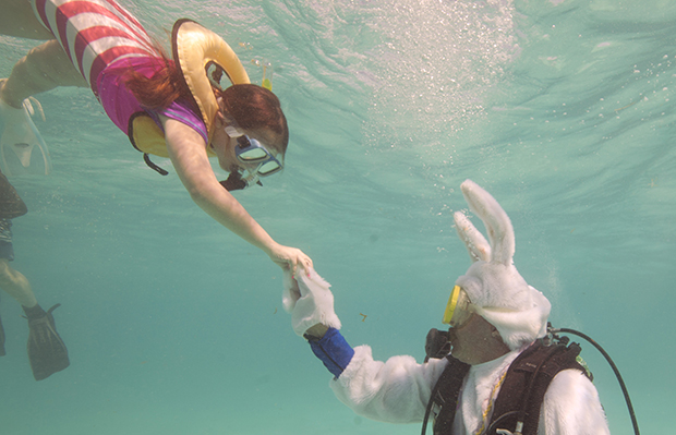 Spencer Slate, right, costumed as a scuba-diving Easter bunny, hands a hard-boiled egg to Quinn Vanischak, Sunday, March 31, 2013, during an Underwater Easter Egg Hunt in the Florida Keys National Marine Sanctuary off Key Largo, Florida. (AP/Florida Keys News Bureau/Bob Care)