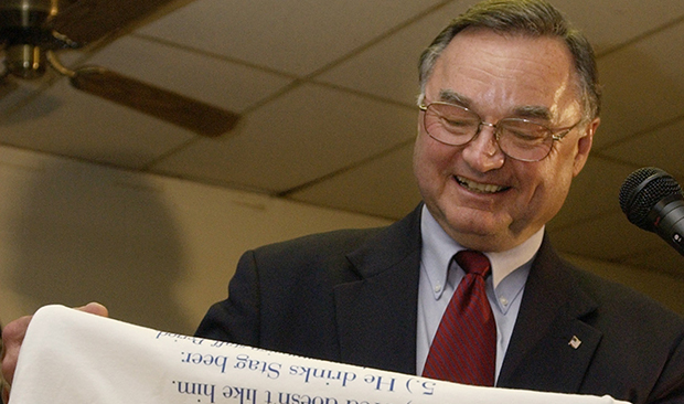 Republican Judge Lloyd A. Karmeier smiles as he reads from a t-shirt,