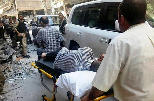 Syrians push a man who allegedly suffered a chemical-weapons attack on a gurney, to show him to the U.N. investigation team in Zamalka, Syria, Wednesday, August 28, 2013. (AP/United media office of Arbeen)