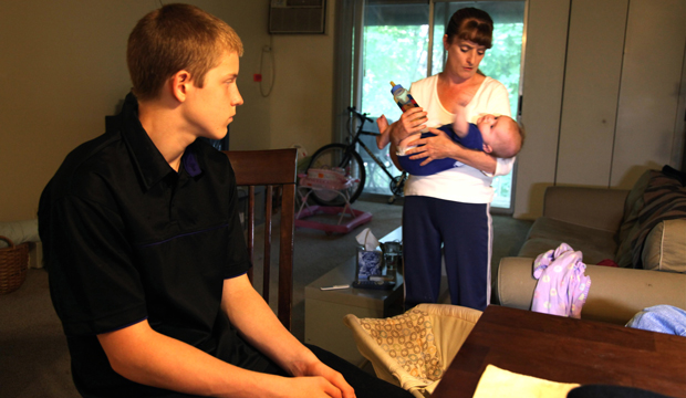In this September 16, 2011 photo, Kris Fallon holds her 4-month-old daughter Addison, in Palatine, Illinois, as her 15-year-old son Gared looks on. The Fallon family has been living in poverty for nearly two years. (AP/Robert Ray)