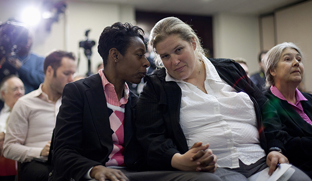 Tracey Cooper-Harris, who served in the Army for 12 years, left, and her spouse, Maggie Cooper-Harris, sit together at a news conference at the National Press Club in Washington, Wednesday, February 1, 2012. (AP/Carolyn Kaster)