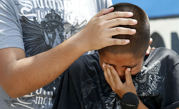 Oscar Hernandez, 11, is comforted by his older brother, Carlos Hernandez. Oscar and Carlos's mother is in jail and facing deportation on immigration charges. (AP/Ross D. Franklin)