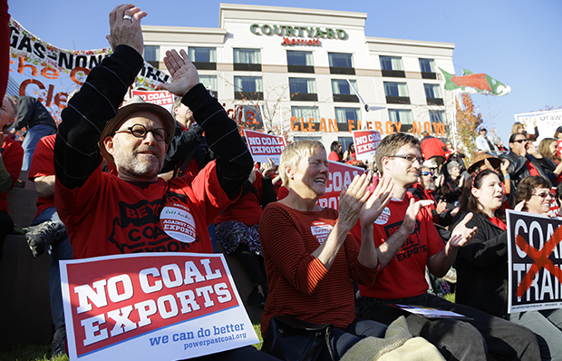 Russ Childers, left, of Seattle, sits among other protesters as they demonstrate against trains carrying coal for export moving through Washington state on Thursday, October 17, 2013, in Tacoma, Washington. (AP/Ted S. Warren)