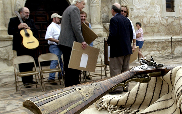 Fess Parker, who gained fame for his portrayal of Davy Crockett in the 1950s Walt Disney TV series, center, visits with Alamo director David Roberts, right, after he presented a 180-year-old Kentucky long rifle to the Alamo for its collection at the Alamo in San Antonio, Friday, March 5, 2004. (AP/Eric Gay)
