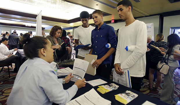 Job seekers Emilio Ferrer, Brian Ferrer, and Jonathan Ferrer of Hollywood, Florida, talk to a FirstService representative at a job fair in Miami Lakes, Florida, Wednesday, August 14, 2013. (AP/Alan Diaz)