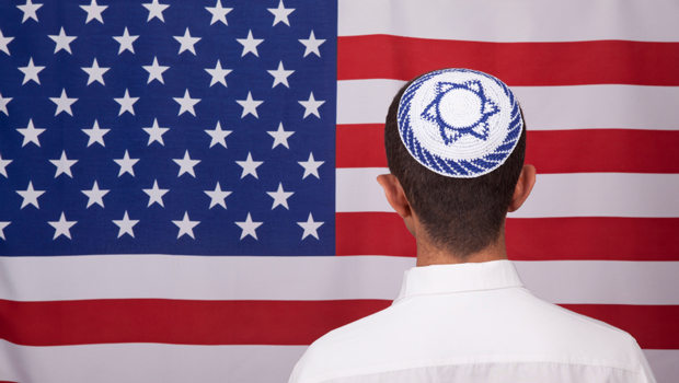 A Jewish boy stands before the American flag. (iStockphoto/selimaksan)
