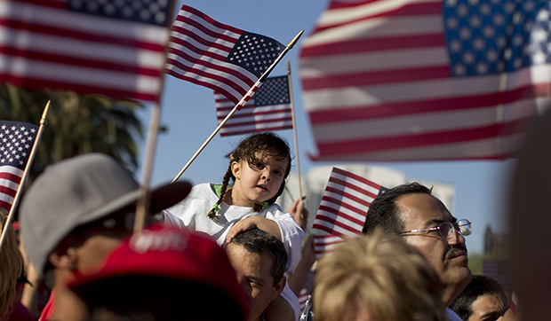 Demonstrators wave American flags as they march down Las Vegas Boulevard during an immigration rally, Wednesday, May 1, 2013, in Las Vegas, Nevada. A new CAP poll shows that Americans are more open to diversity than media and politics would lead us to believe. (AP/JulieJacobson)
