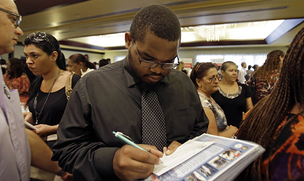 Job seeker Kelsey Devoe of Miramar, Florida, fills out a contact form at a job fair in Miami Lakes, Florida, Wednesday, August, 14, 2013. (AP/Alan Diaz)
