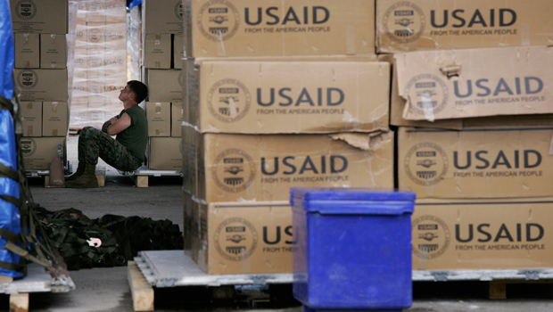 A U.S. Marine rests against palates of USAID supplies bound for cyclone-devastated Myanmar at the Utapao Air Force base near the southern city of Rayong, Thailand, Wednesday, May 14, 2008. (AP/Wally Santana)