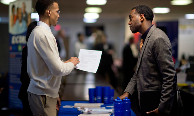 Retired U.S. Air Force Master Sgt. Thomas Gipson, of Atlanta, right, has his resume looked over by Ralph Brown, a management and program analyst with the Centers for Disease Control and Prevention, during a job fair for veterans at the VFW Post 2681, Thursday, November 14, 2013, in Marietta, Georgia. (AP/David Goldman)