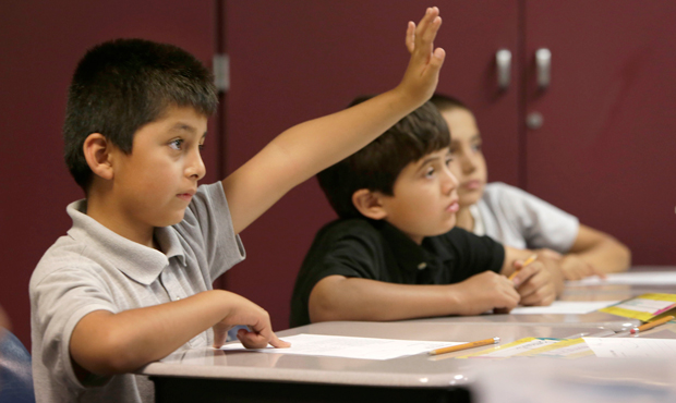 Emmanuel Angeles raises his hand to be called on while doing a worksheet in an English language learner summer school class at the Cordova Villa Elementary School, Wednesday, June 12, 2013 in Rancho Cordova, California. (AP/Rich Pedroncelli)