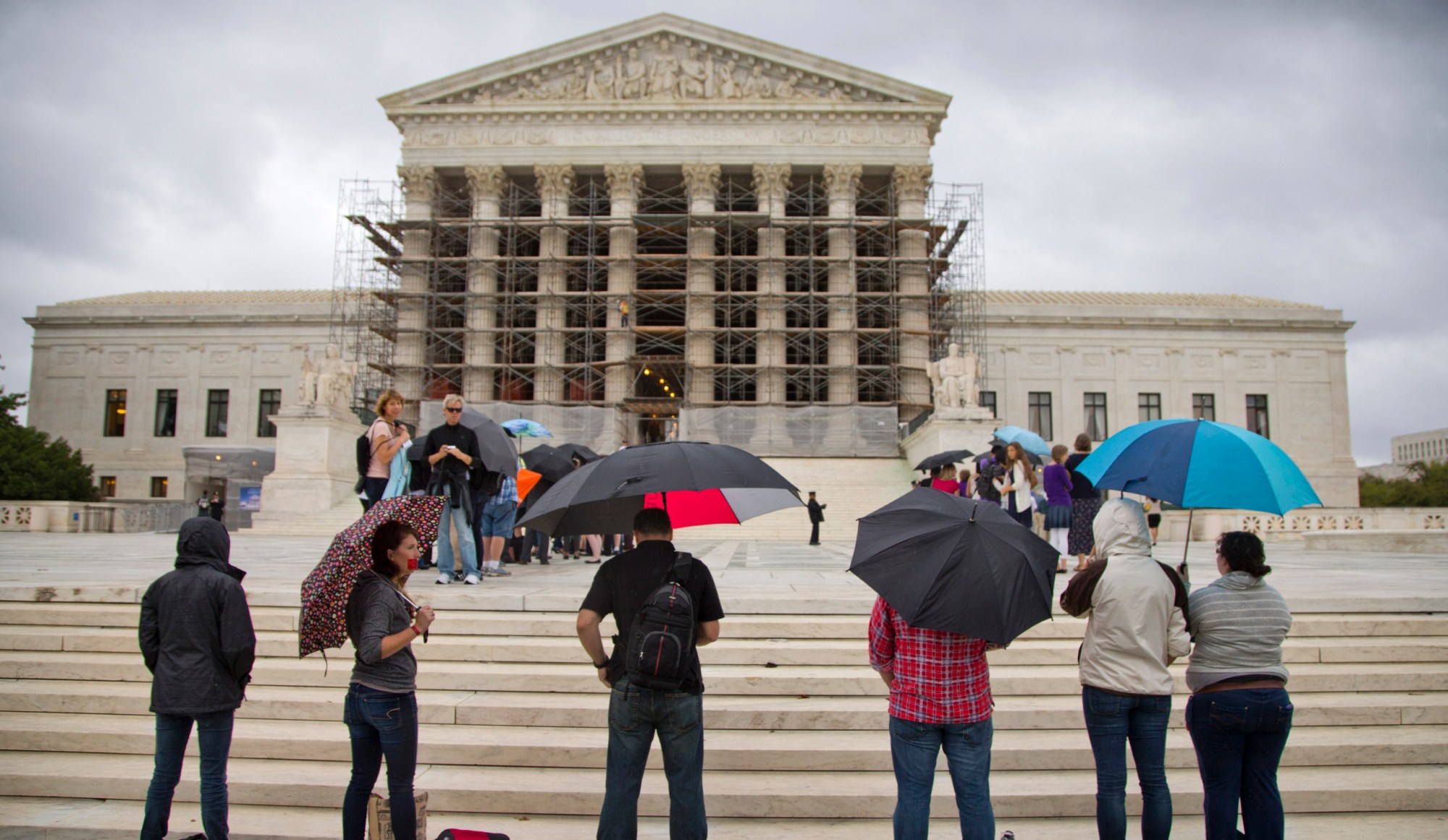 Observers stand outside the U.S. Supreme Court on the first day of the 2013–14 term. One of this season's cases deals with government-sanctioned prayer. (AP/Evan Vucci)