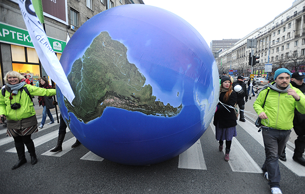 Climate activists roll a giant globe during an environmentalist march to campaign against global warming in downtown Warsaw, Poland, Saturday, November 16, 2013. (AP/Alik Keplicz)