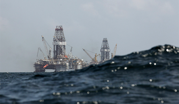 A swell partially obscures the Development Driller II, left, and Development Driller III, which are drilling the relief wells at BP's Deepwater Horizon oil spill site in the Gulf of Mexico off the Louisiana coast, Thursday, July 22, 2010. (AP/Gerald Herbert)