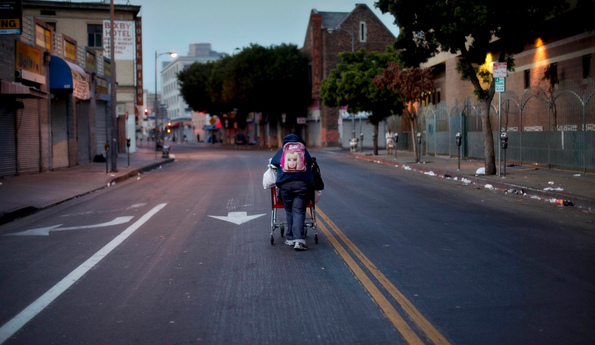 A homeless woman pushes a shopping cart full of her belongings down the street in the Skid Row area of Los Angeles. (AP/Jae C. Hong)