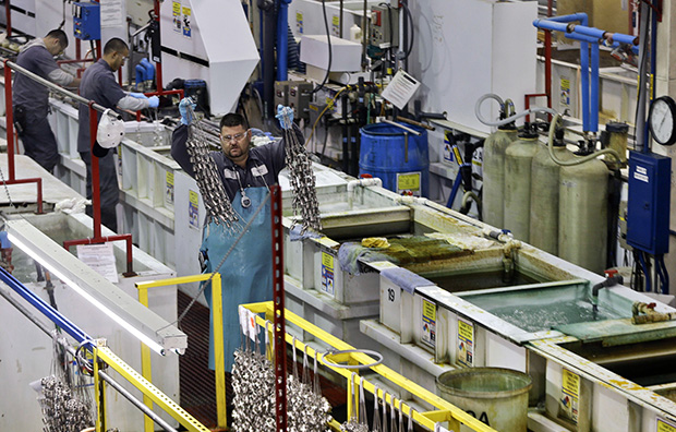 Employees at Sheffield Platers, Inc. work on the factory floor in San Diego, California, October 10, 2013. (AP/Lenny Ignelzi)